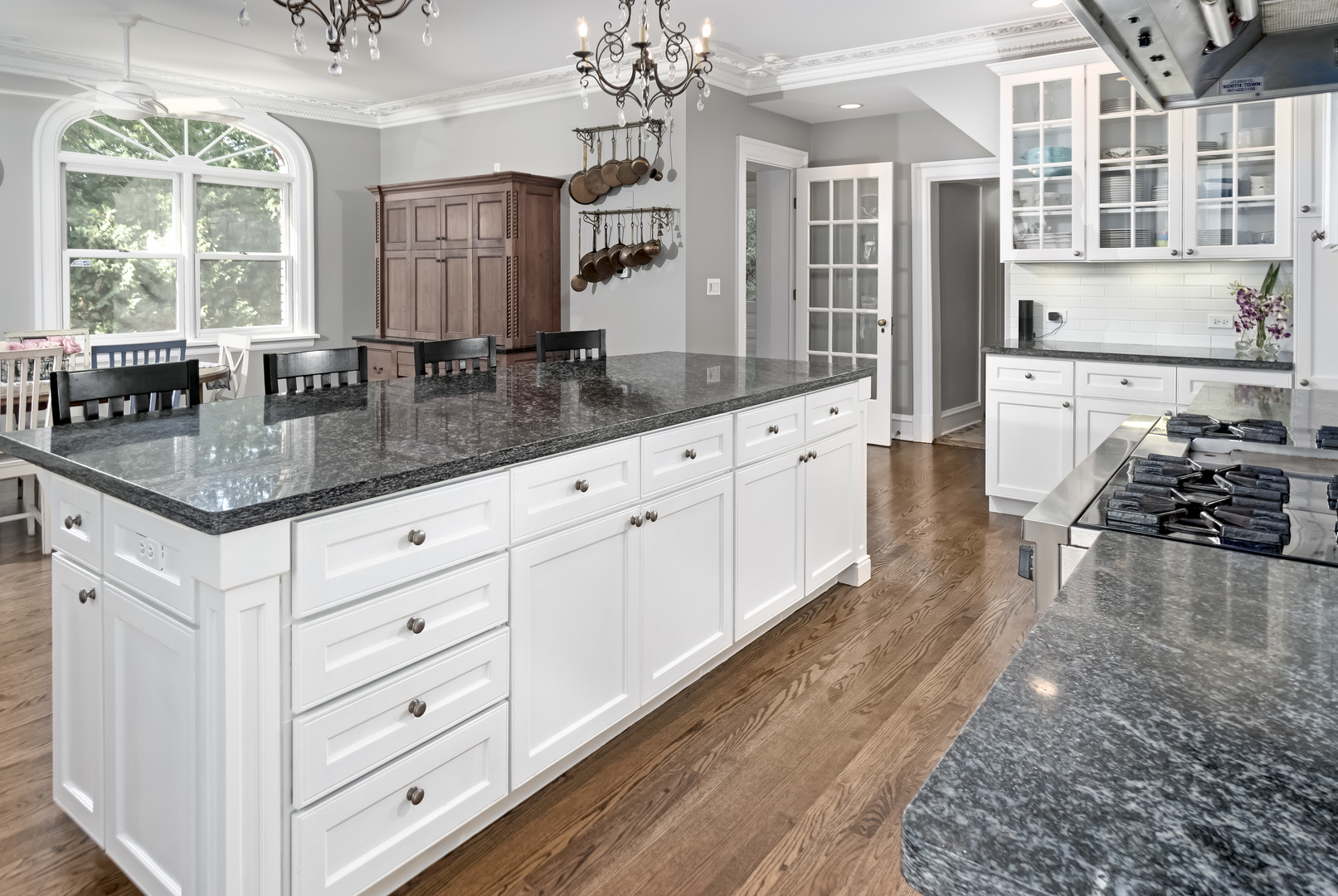 1111 Sheridan Road Wilmette, IL 60091 - Photo 21 of 76 a kitchen with granite countertop a sink dishwasher a dining table and chairs with wooden floor