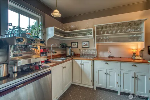 a kitchen with white cabinets and window
