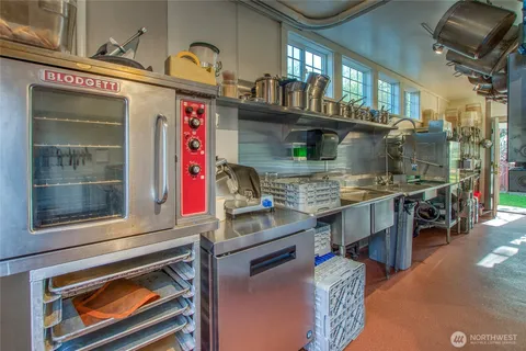 a kitchen with stainless steel appliances granite countertop a sink and a wooden floor