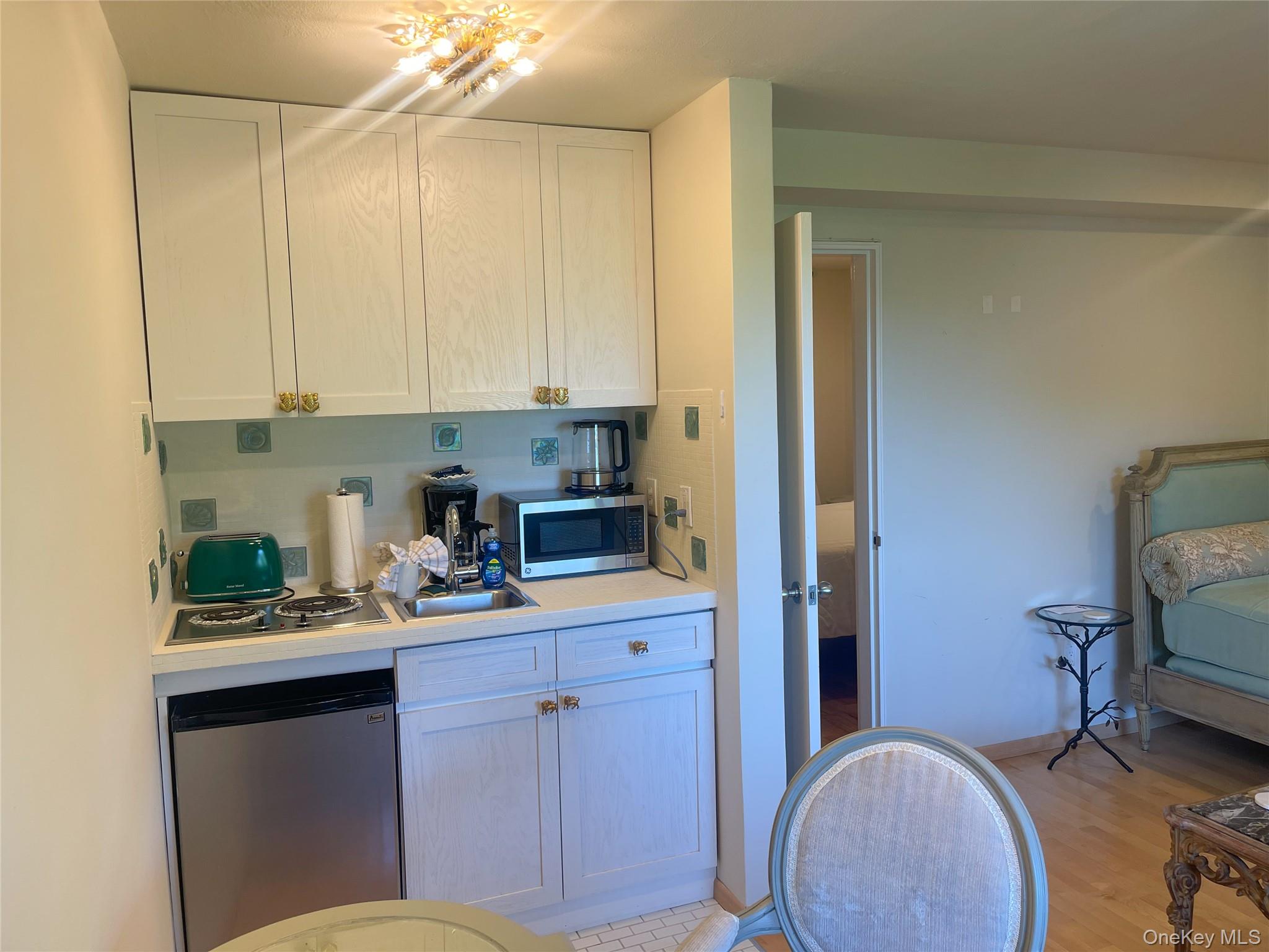 379 Bluff Road, Unit 115 Amagansett, NY 11930 - Photo 15 of 28 a kitchen with a sink a stove cabinets and a window