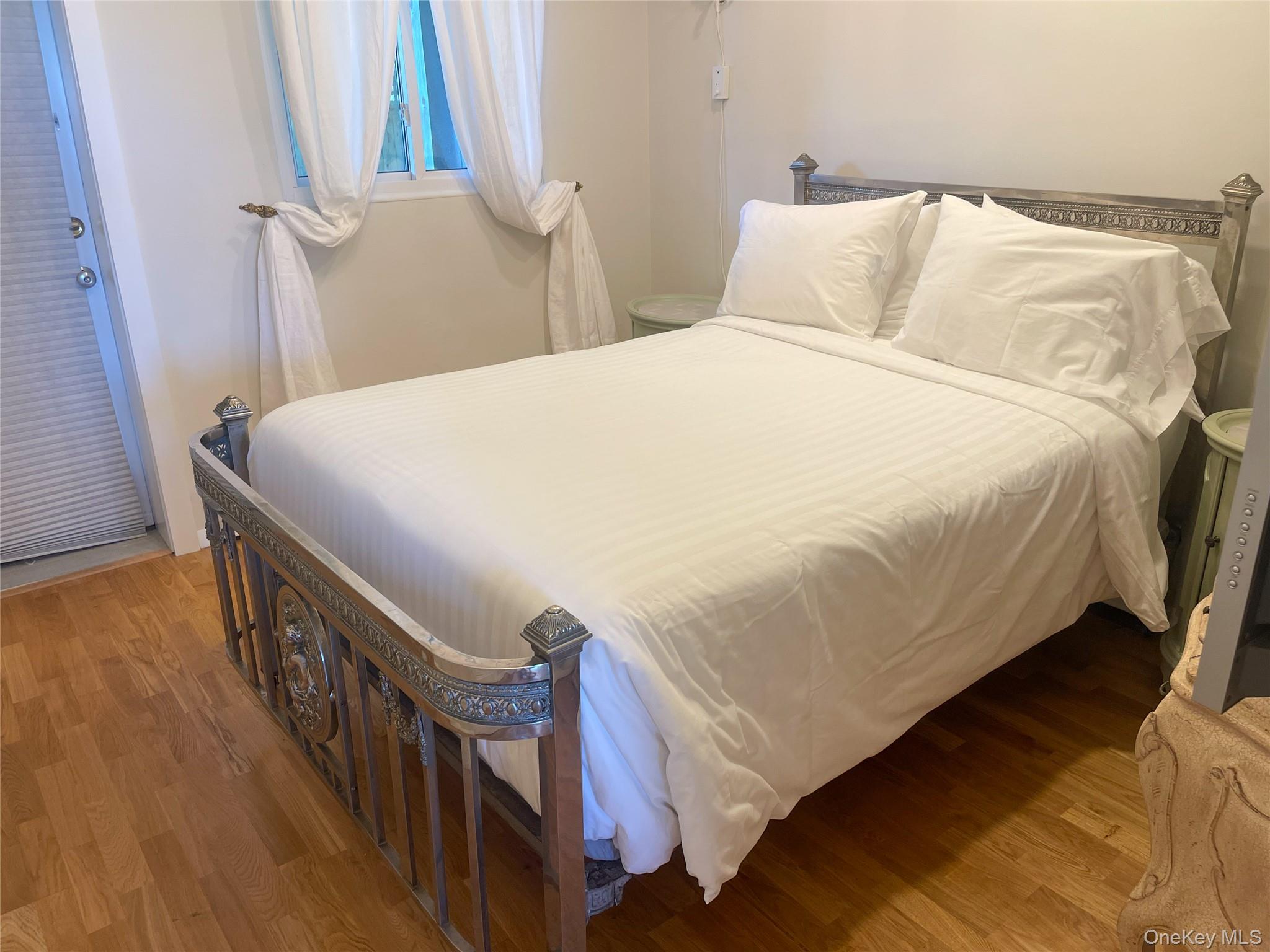 379 Bluff Road, Unit 115 Amagansett, NY 11930 - Photo 16 of 28 a bedroom with bed and wooden floor