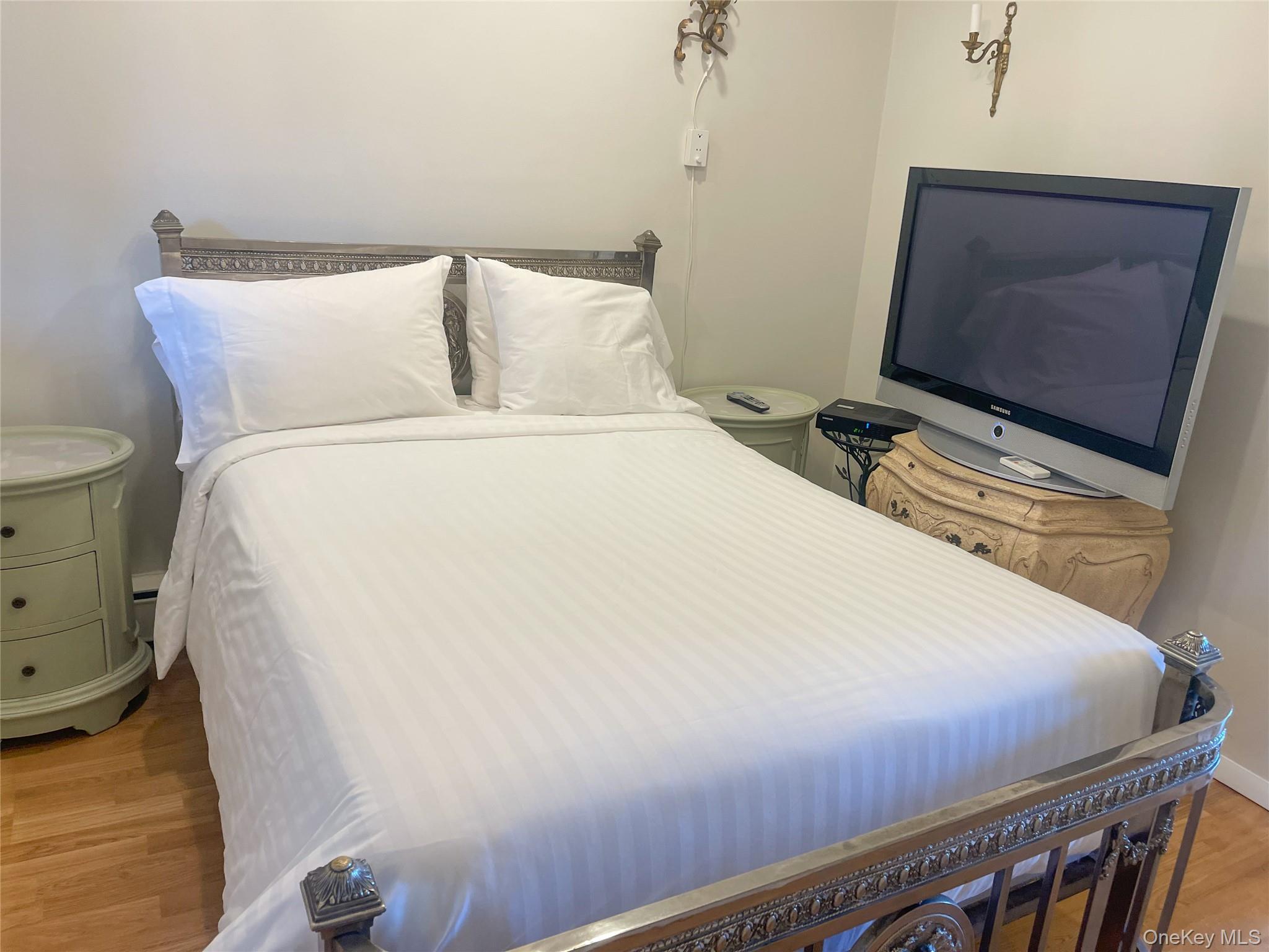379 Bluff Road, Unit 115 Amagansett, NY 11930 - Photo 20 of 28 a bedroom with a bed and a flat screen tv