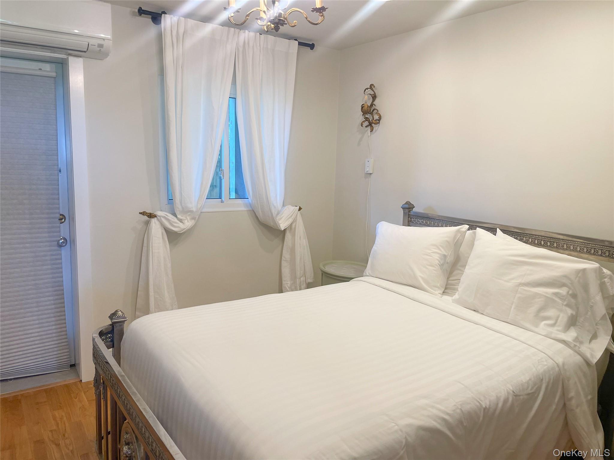 379 Bluff Road, Unit 115 Amagansett, NY 11930 - Photo 21 of 28 a bedroom with a bed and a table