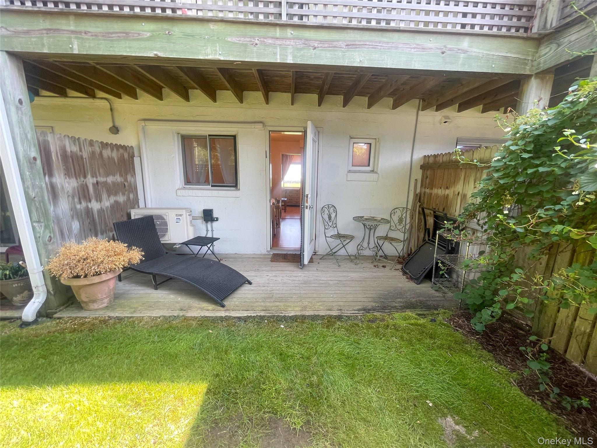 379 Bluff Road, Unit 115 Amagansett, NY 11930 - Photo 22 of 28 a view of a patio with table and chairs potted plants