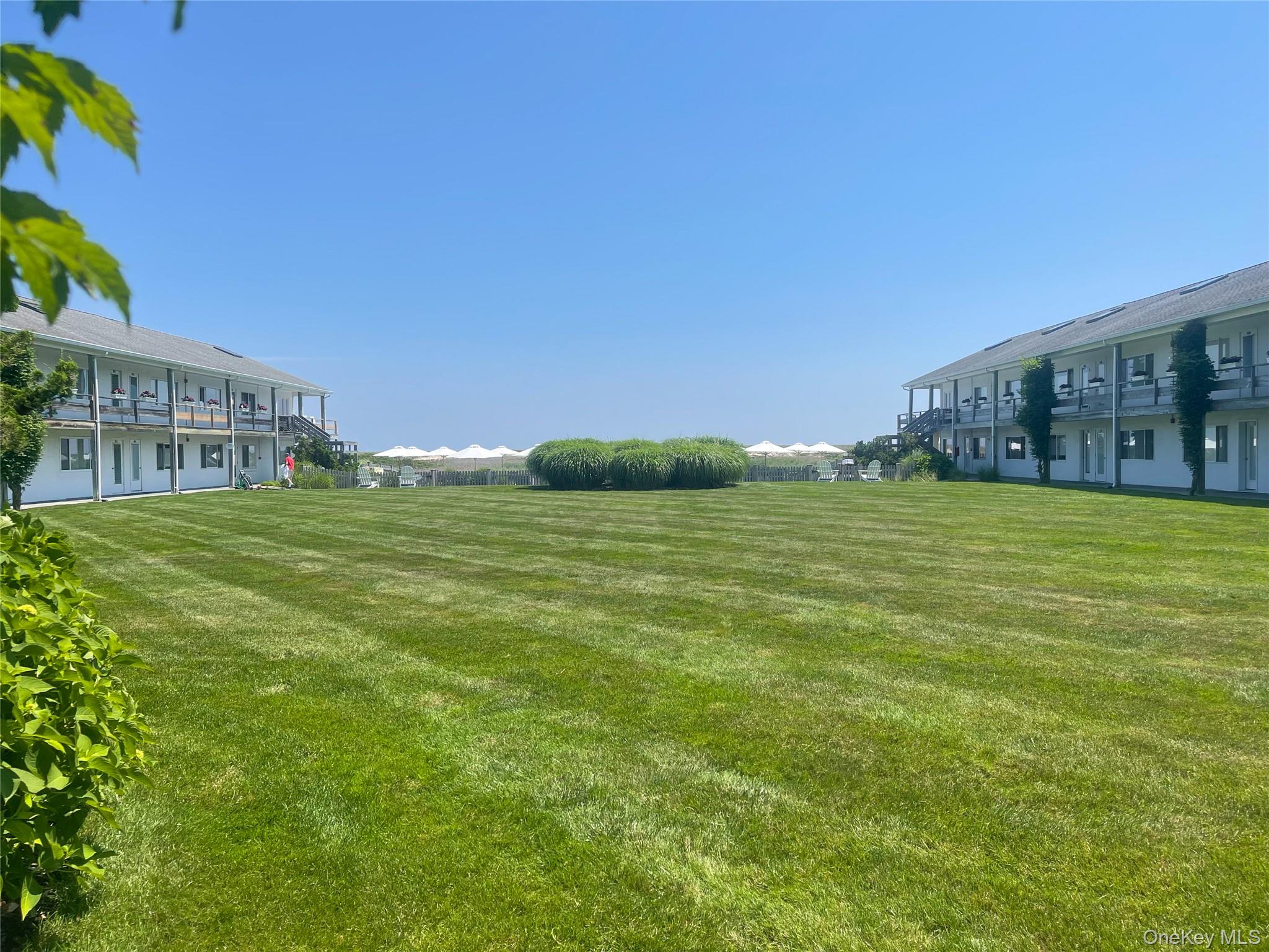 379 Bluff Road, Unit 115 Amagansett, NY 11930 - Photo 5 of 28 a view of a building with an outdoor space and seating