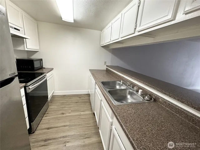 a kitchen with granite countertop a stove and a sink