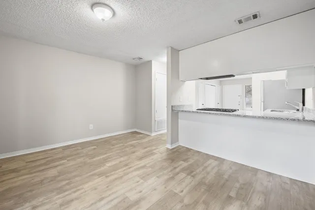 a view of a kitchen with white cabinets and a refrigerator