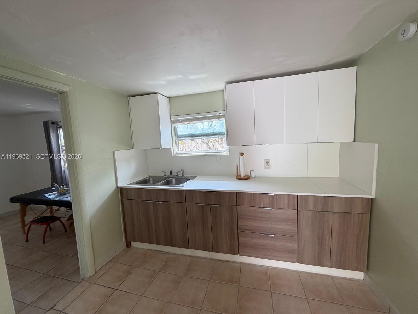 9770 Southwest 47th Street, Unit 2 Miami, FL 33165 - Photo 3 of 9 a room with a chair and cabinets