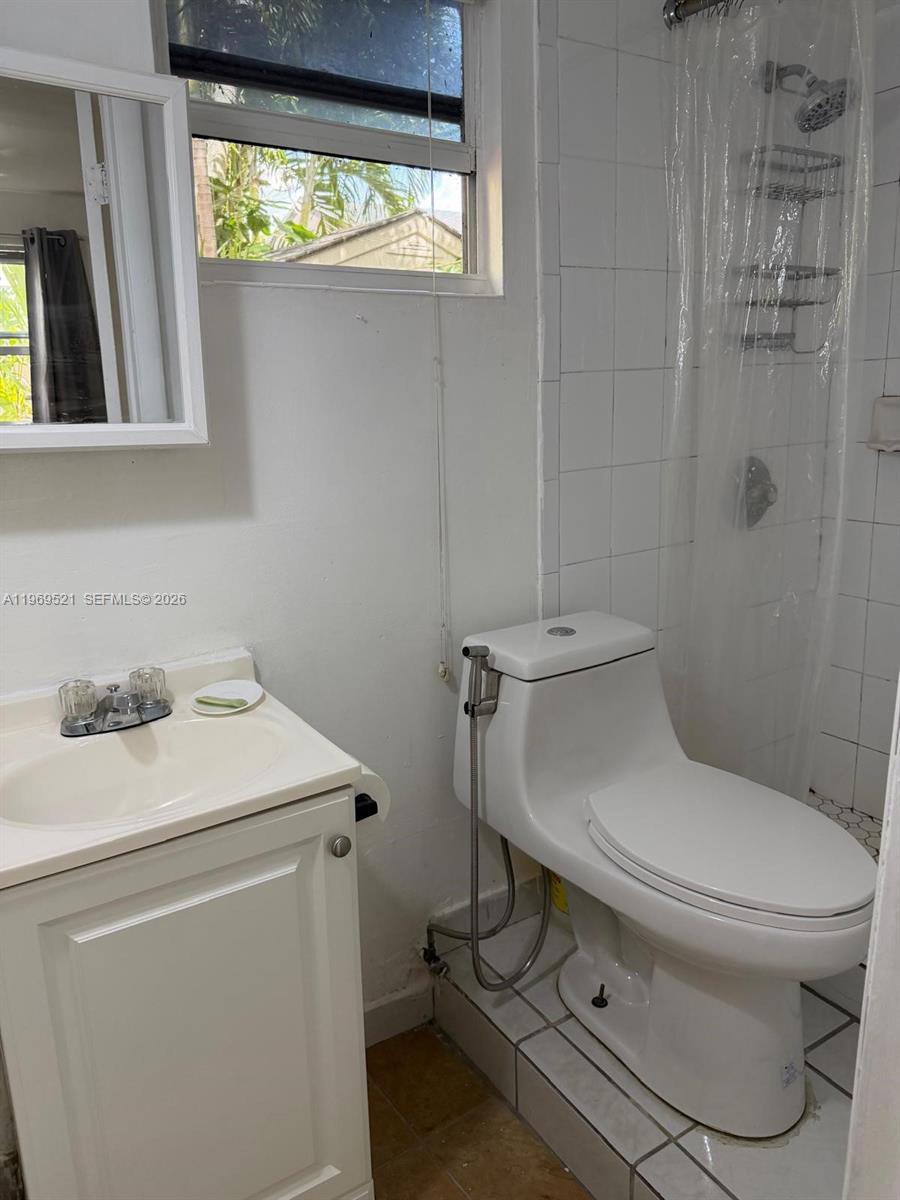 9770 Southwest 47th Street, Unit 2 Miami, FL 33165 - Photo 7 of 9 a bathroom with a sink toilet and window