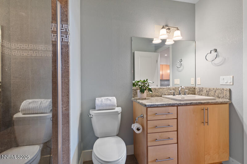 374 State Street Reno, NV 89501 - Photo 8 of 16 a bathroom with a toilet a sink and mirror