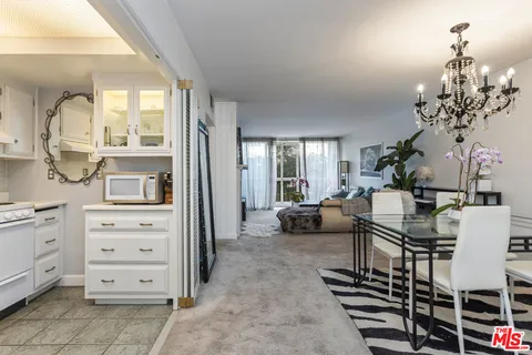 a view of a livingroom with furniture a chandelier and window