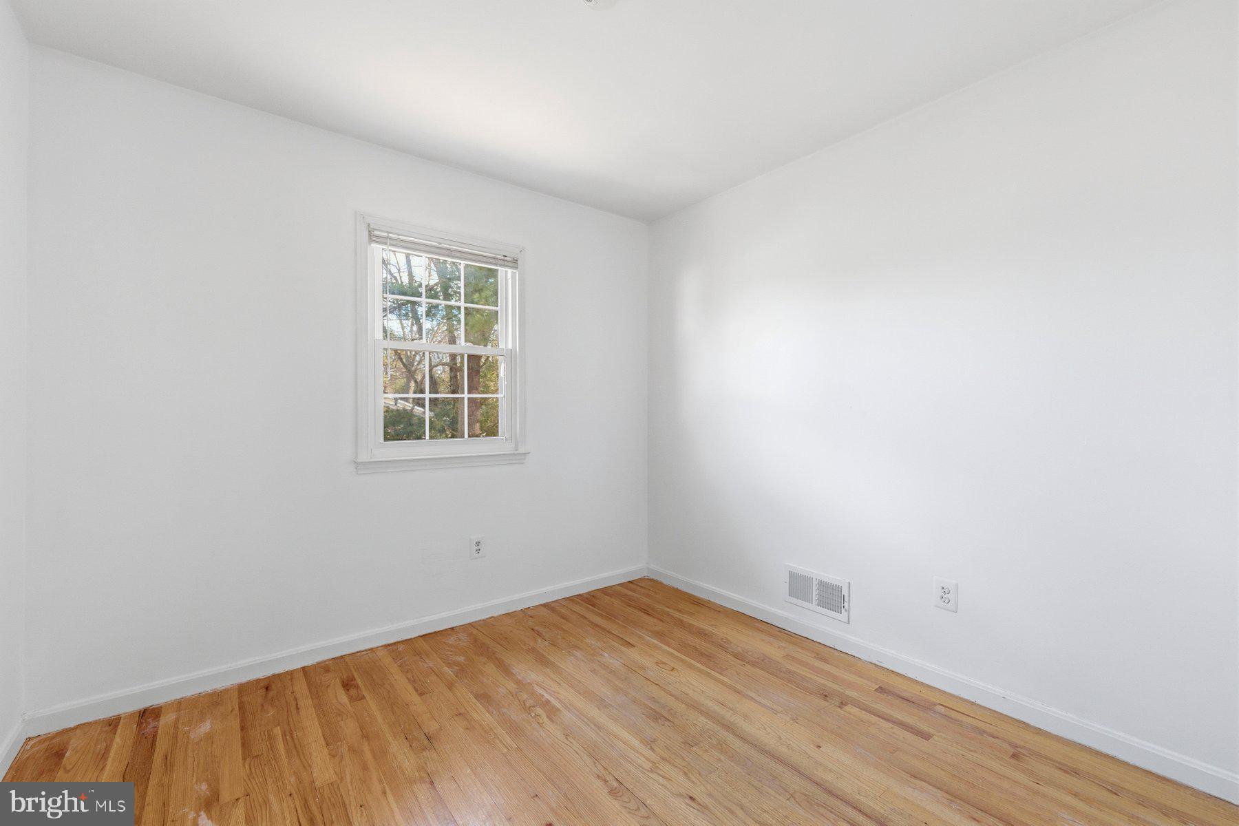 11733 Becket Street Potomac, MD 20854 - Photo 17 of 27 an empty room with wooden floor and windows