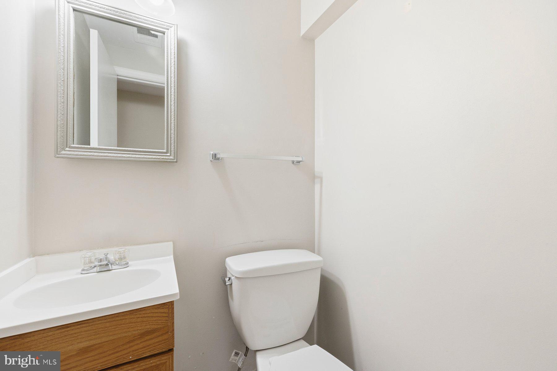 11733 Becket Street Potomac, MD 20854 - Photo 23 of 27 a bathroom with a toilet sink and mirror