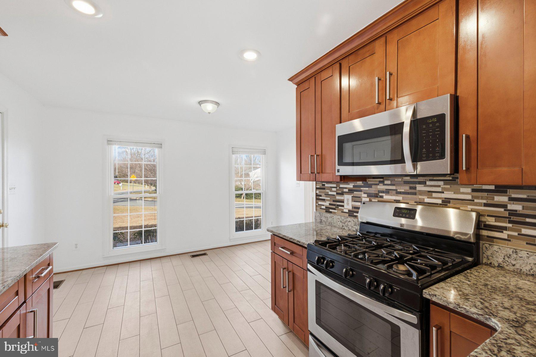 11733 Becket Street Potomac, MD 20854 - Photo 6 of 27 a kitchen with stainless steel appliances a stove a microwave and cabinets