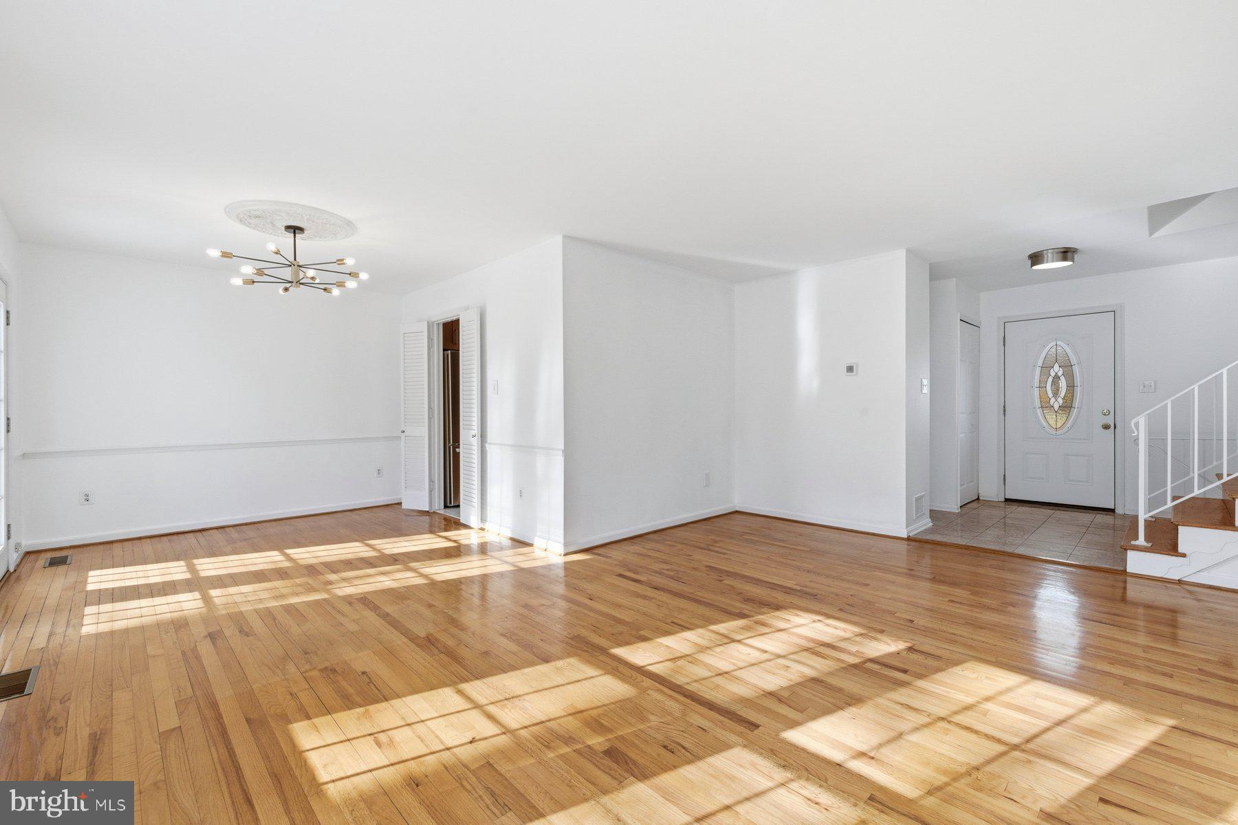 11733 Becket Street Potomac, MD 20854 - Photo 8 of 27 a view of a livingroom with wooden floor and a chandelier