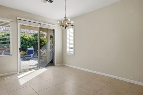 a view of a livingroom with a chandelier a ceiling fan and windows
