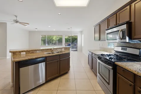 a kitchen with stainless steel appliances granite countertop a stove a sink and a microwave