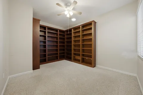 a view of an empty room with a cabinet and a ceiling fan