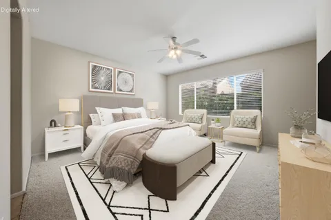 a spacious bedroom with a bed a couch and a large window