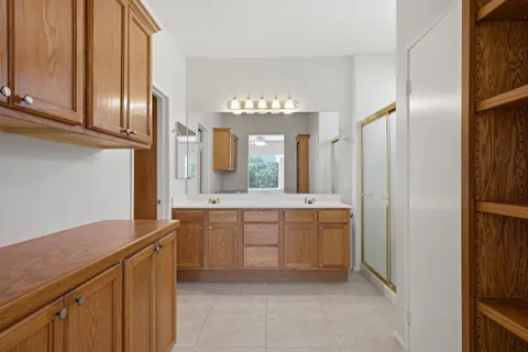 a large bathroom with a double vanity sink a mirror and a bathtub
