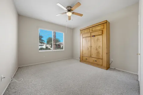 an empty room with windows and ceiling fan