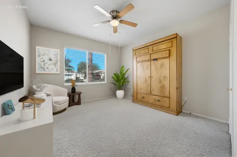 a living room with furniture a flat screen tv and a large window