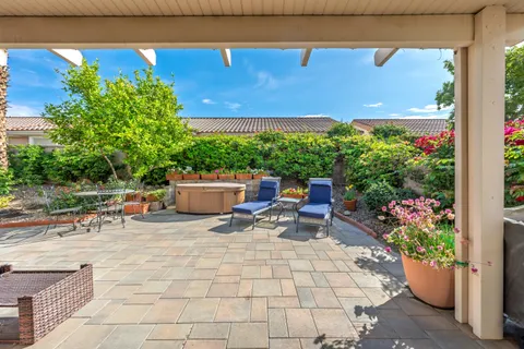 a view of a chairs and table in a back yard of a house