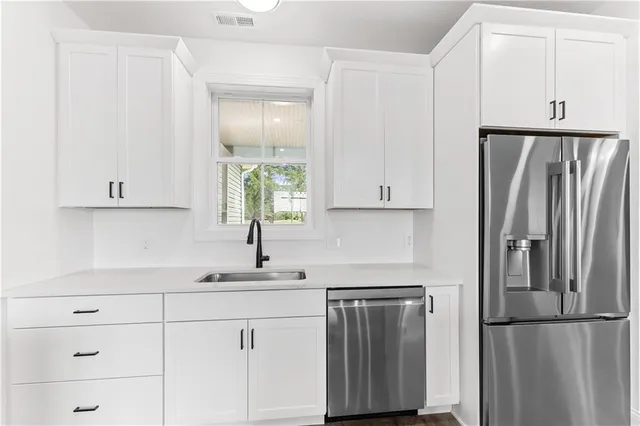 a kitchen with refrigerator a sink and cabinets
