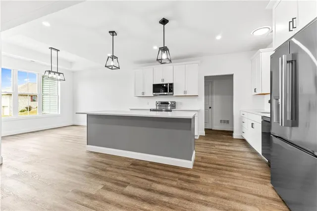 a large kitchen with stainless steel appliances granite countertop a sink a stove and a refrigerator