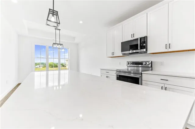 a kitchen with stainless steel appliances a stove a sink and white cabinets