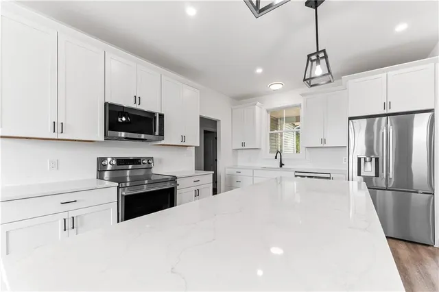 a kitchen with stainless steel appliances a refrigerator stove microwave and cabinets