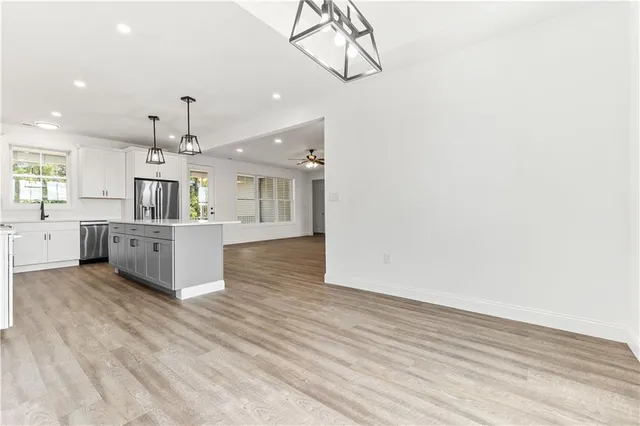 a large kitchen with cabinets wooden floor and stainless steel appliances