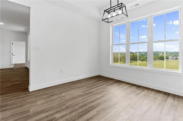 a view of a livingroom with wooden floor and windows