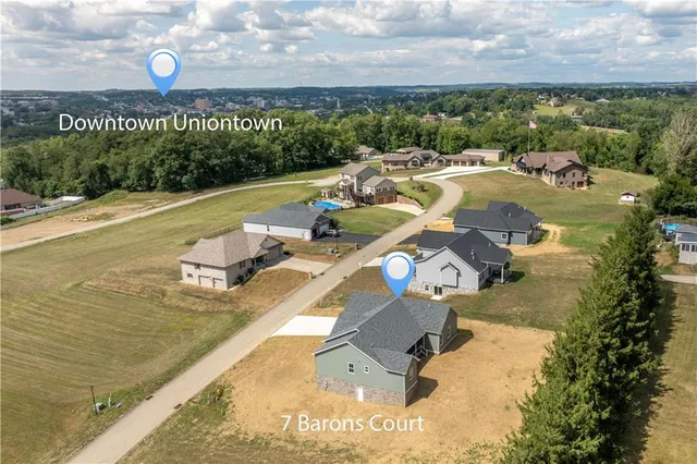 an aerial view of a house with swimming pool and outdoor seating