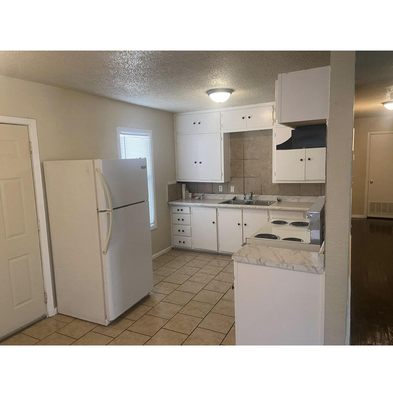 2411 Cedar Avenue Lubbock, TX 79404 - Photo 3 of 6 a kitchen with a refrigerator and a sink