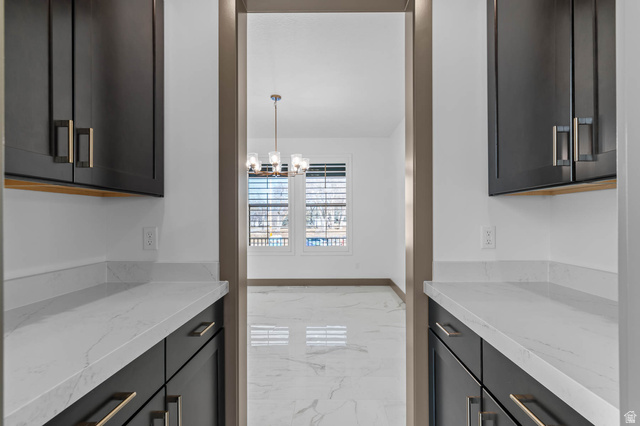 2724 Mt Jordan Road Sandy, UT 84092 - Photo 18 of 33 Kitchen featuring light stone counters, light marble finish floors, and hanging lights