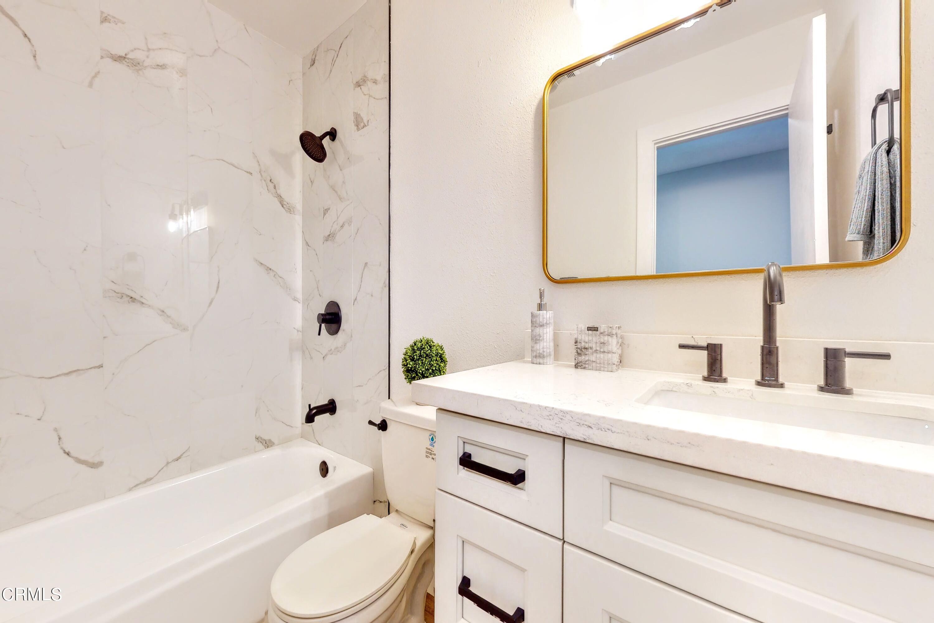 263 South Ventura Road, Unit 272 Port Hueneme, CA 93041 - Photo 25 of 40 a bathroom with a granite countertop sink toilet a mirror a bathtub and shower