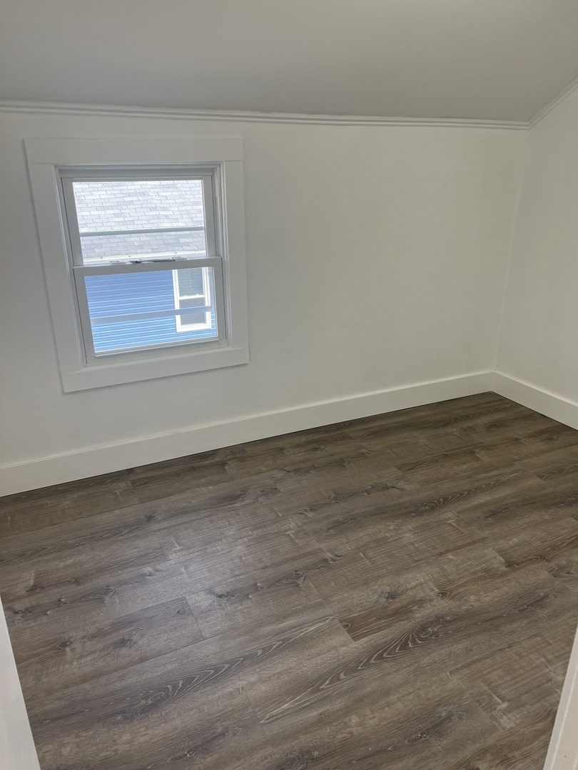7446 64th Street, Unit 2F Summit, IL 60501 - Photo 7 of 14 a view of an empty room with wooden floor and a window