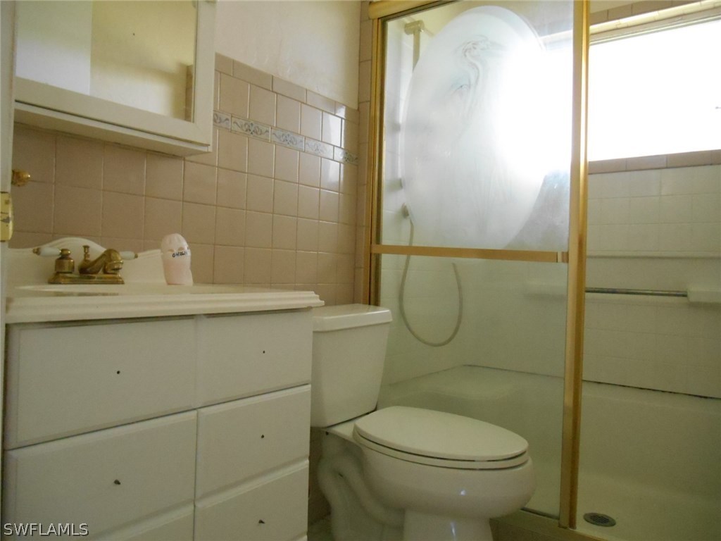 30399 Holly Road Punta Gorda, FL 33982 - Photo 4 of 5 a bathroom with a sink a toilet and shower