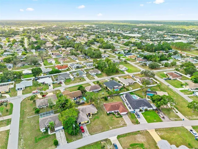 an aerial view of residential houses with outdoor space and trees