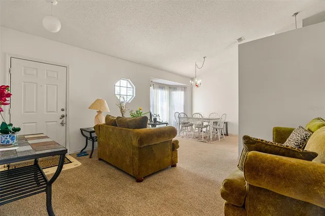 a living room with furniture and a chandelier