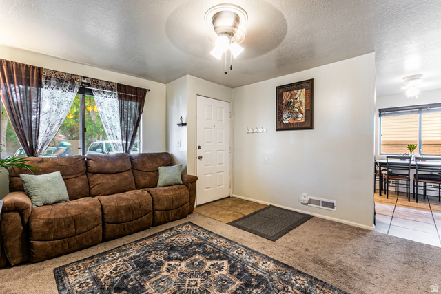 947 Canyon Road, Unit 33 Ogden, UT 84404 - Photo 2 of 19 Living area featuring light-colored walls, carpet flooring, a front entry door with a multi-pane design, and a ceiling fan with integrated lighting