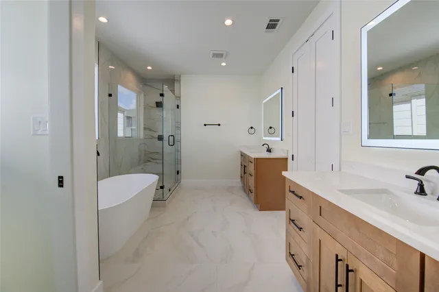 a bathroom with a double vanity sink toilet mirror and shower