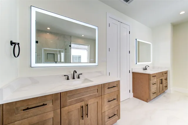 a bathroom with a double vanity sink mirror and bathtub