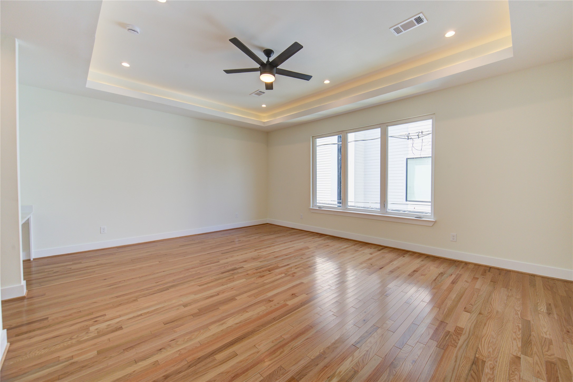 1810 Hazard Street, Unit A Houston, TX 77019 - Photo 20 of 47 an empty room with wooden floor ceiling fan and windows