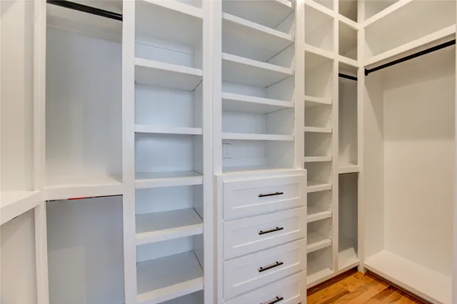 a view of walk in closet with empty racks