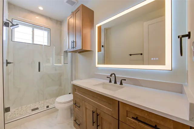 a bathroom with a sink a toilet and shower