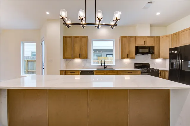 a kitchen with kitchen island a sink stainless steel appliances and cabinets