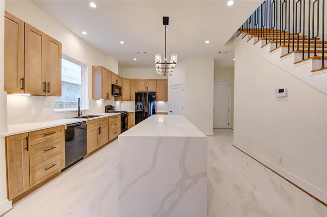 a large white kitchen with lots of counter space a sink and cabinets
