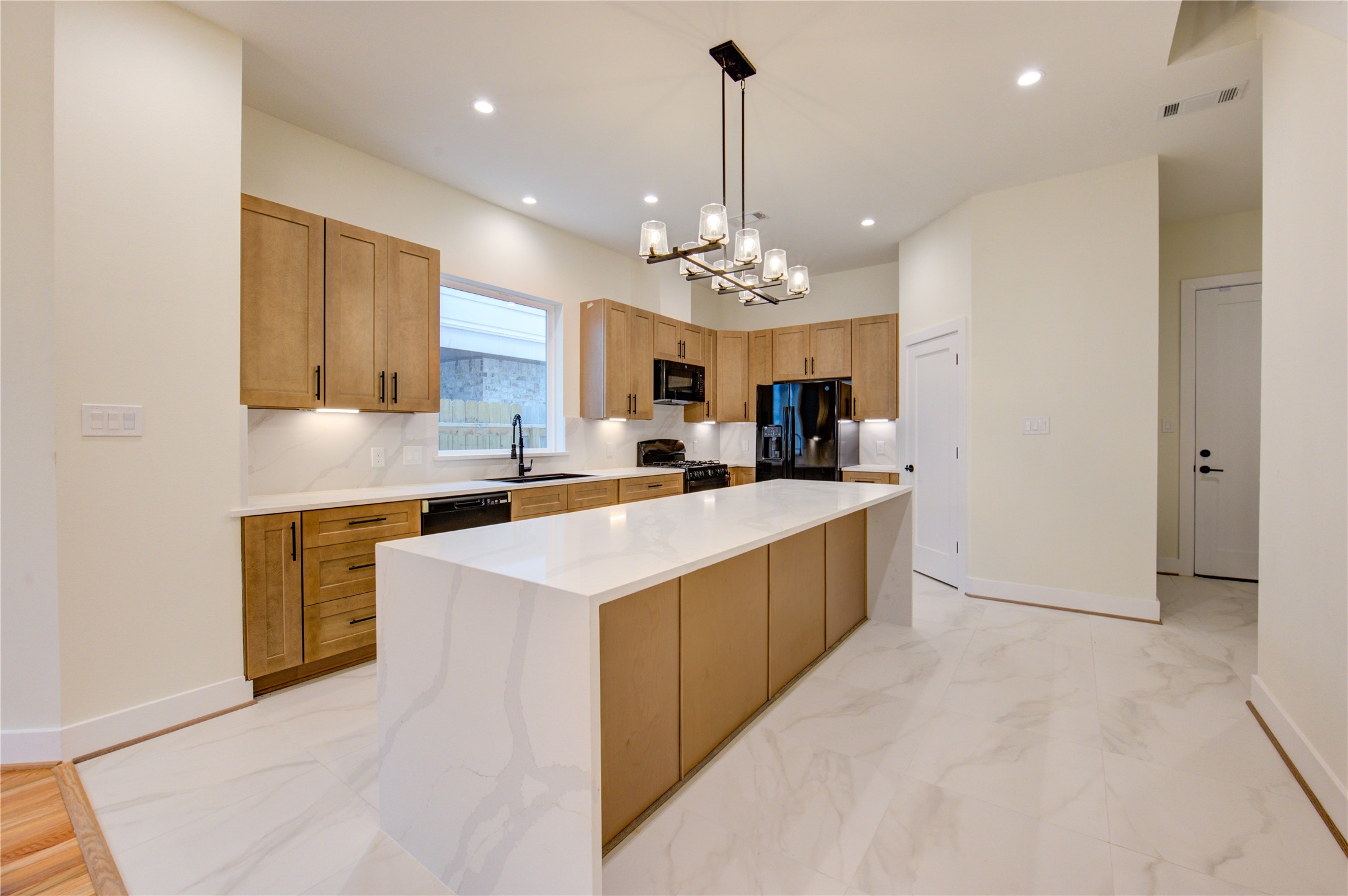 1810 Hazard Street, Unit A Houston, TX 77019 - Photo 36 of 47 a large kitchen with kitchen island a sink stainless steel appliances and cabinets